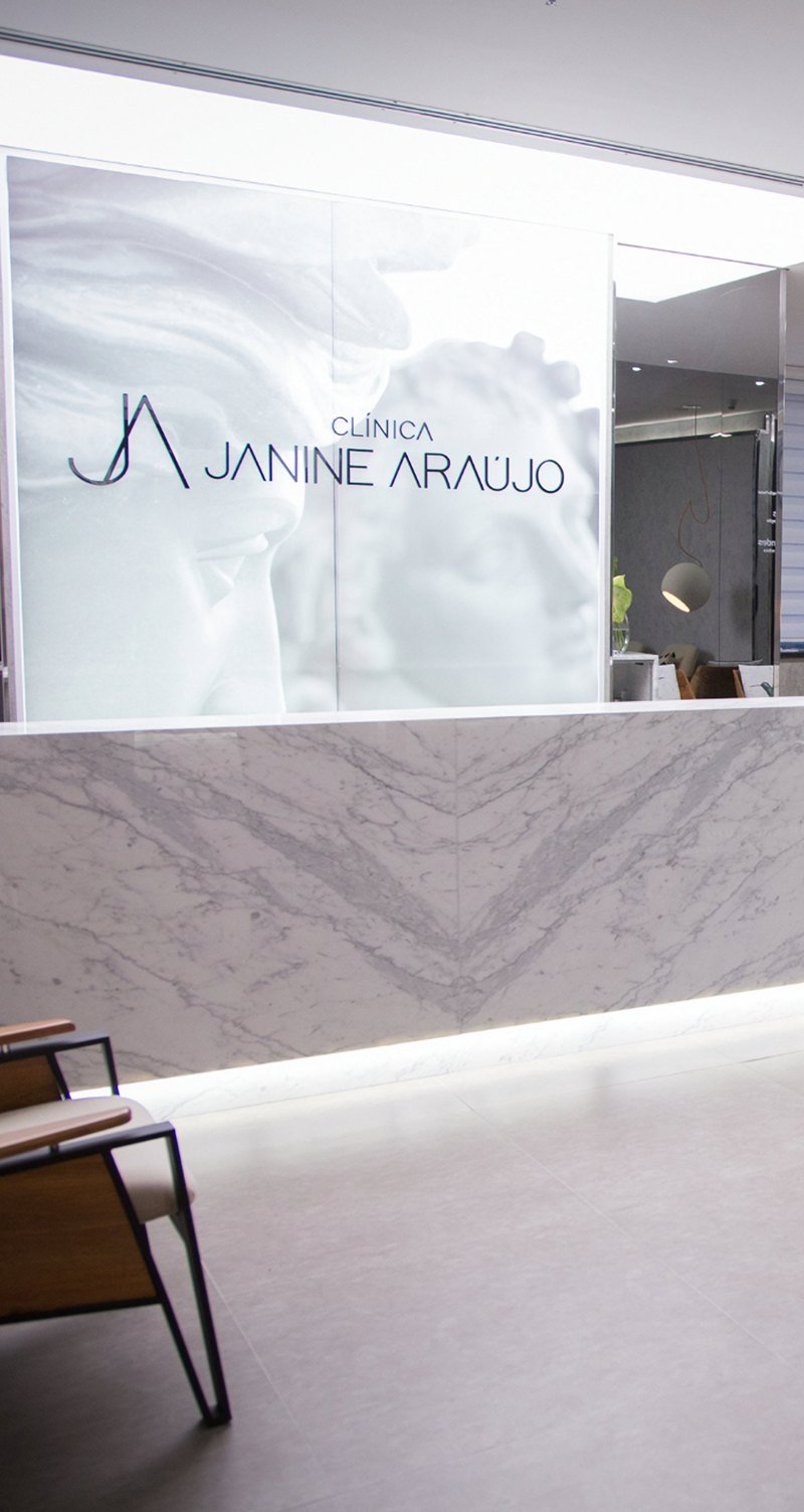 Recepção da Clínica Janine Araújo, com balcão de mármore
